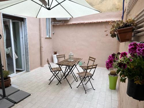 a patio with a table and chairs and an umbrella at Mama House in Naples
