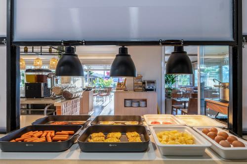 a buffet with many trays of food on a counter at Time to Smile Saline in Tigaki
