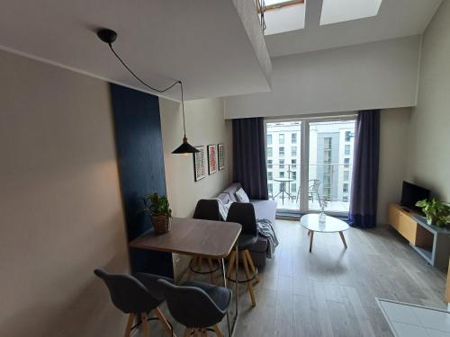 a living room with a table and chairs and a couch at Hotel Marina Club Old Town View in Gdańsk