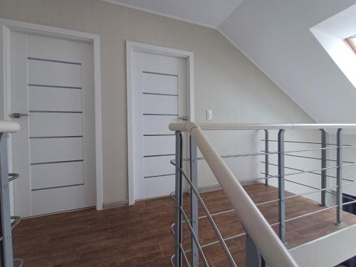 an attic room with white doors and a staircase at Hotel Marina Club Old Town View in Gdańsk
