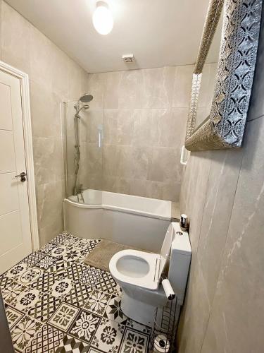 a bathroom with a toilet and a bath tub at Cosy three bedroom house in Ballingarry Limerick near Adare in Balnacart