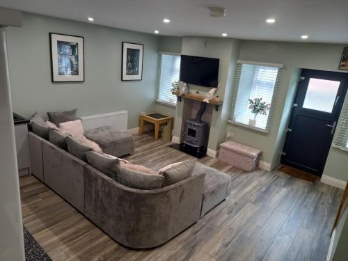 a living room with two couches and a television at Cosy three bedroom house in Ballingarry Limerick near Adare in Balnacart