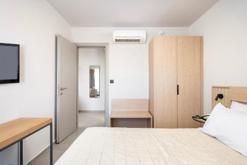a bedroom with a bed and a desk in a room at Time to Smile Saline in Tigaki