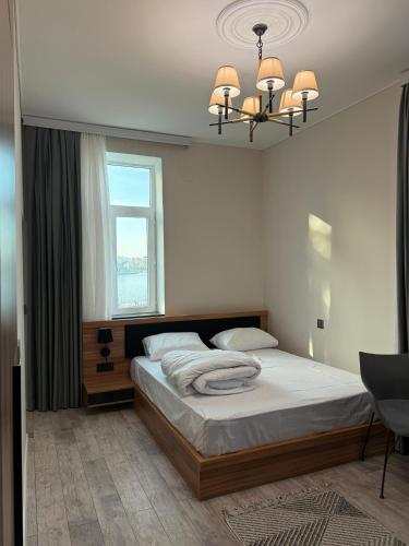 una camera con letto, finestra e lampadario a braccio di Studio Near Flag Square with Seaview a Baku