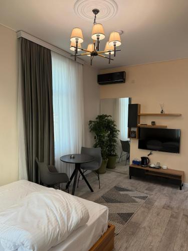 una camera da letto con un letto, un tavolo e una TV di Studio Near Flag Square with Seaview a Baku