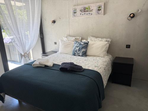 - une chambre avec un lit doté d'une couverture bleue et d'oreillers dans l'établissement Gites Les Rochers de Plaisians, à Plaisians