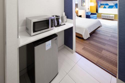 a hotel room with a microwave on a counter at Holiday Inn Express & Suites Chicago West - St Charles by IHG in Saint Charles