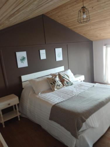 a bedroom with a large bed with a wooden ceiling at Casa Patagónica Los Charitos in El Chalten