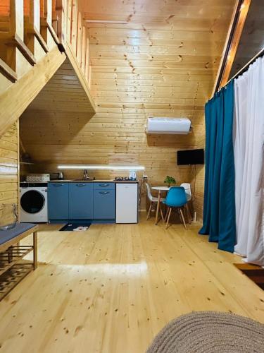 a kitchen with blue cabinets and a wooden wall at Cozy Home Buknari in Buknari