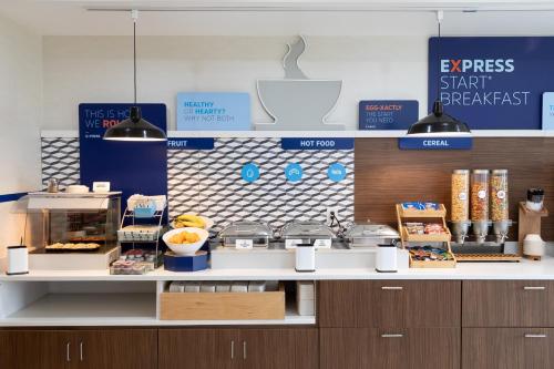 a bakery with a counter with food on it at Holiday Inn Express & Suites Chicago West - St Charles by IHG in Saint Charles