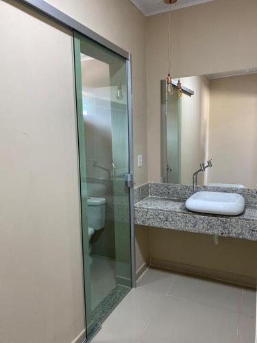 a bathroom with a glass shower and a sink at Pousada Itajuipe II in Vitória da Conquista