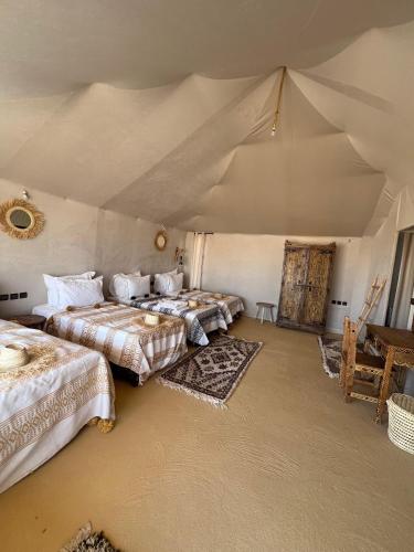 Zimmer mit 3 Betten in einem Zelt in der Unterkunft Oracle Desert Camp in Merdani