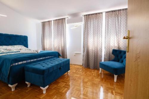 a bedroom with a blue bed and two blue chairs at Apartment Sunset Cove in Neum