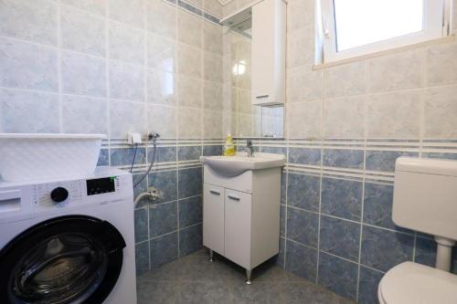 a bathroom with a washing machine and a sink at Apartment Sunset Cove in Neum