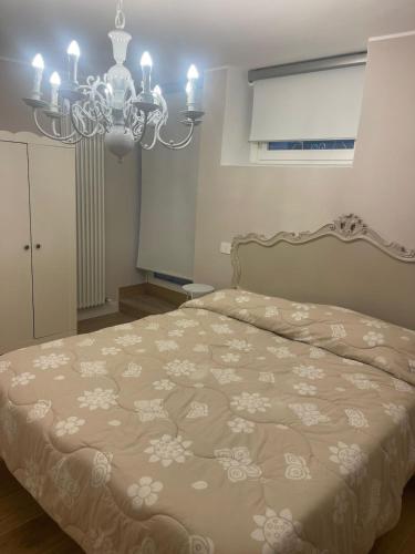 a bedroom with a bed and a chandelier at Maison Simo in Pescasseroli