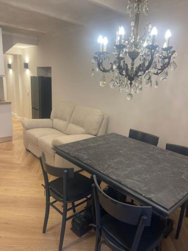 a living room with a table and a chandelier at Maison Simo in Pescasseroli