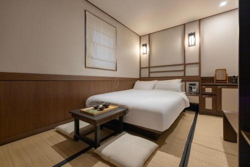 a hotel room with a bed and a table at Yuhyu Ryokan Hotel in Seoul