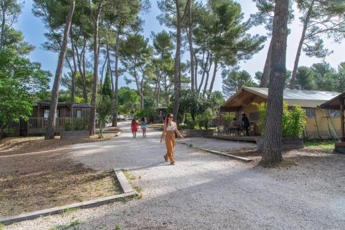 欧巴涅Youcamp Village - Marseille Provence的一名女子在公园的路上行走