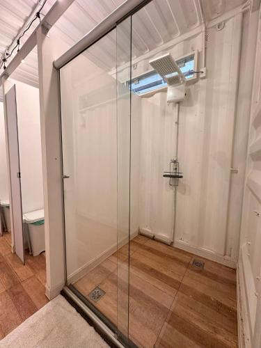 a glass shower in a room with a window at Flat do Burle Marx Villela Home Stay Lago Sul DF in Brasília