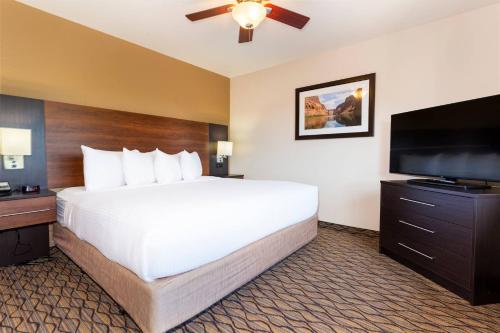 a hotel room with a large bed and a flat screen tv at Grand Canyon Hotel & Suites in Tusayan