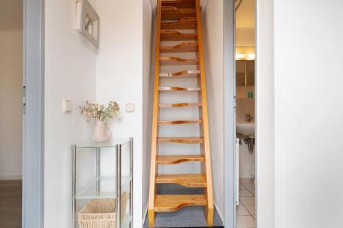 a wooden staircase in a room with a mirror at Zur lachenden Möwe in Grömitz