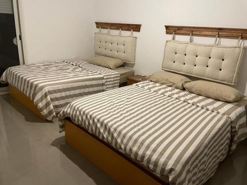 two beds sitting next to each other in a room at Almaza bay Beach Town Chalet in Marsa Matruh