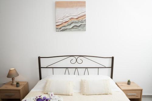 a bedroom with a black and white bed with two night stands at F & A Family Home in Zarós