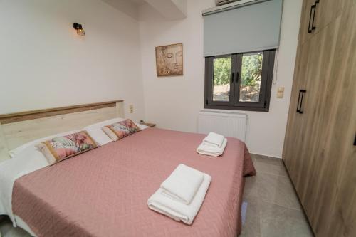 a bedroom with a bed with two towels on it at F & A Family Home in Zarós