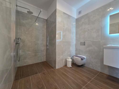a bathroom with a shower and a toilet at Punta Mare Hotel in Karpathos Town
