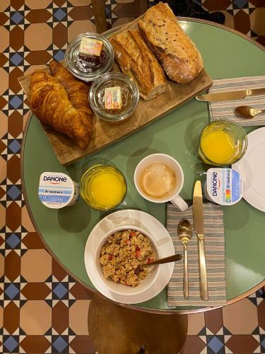 a table with a plate of bread and a bowl of food at B&B L'Escapade Bordelaise in Bordeaux