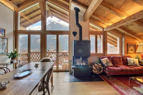 a living room with a fireplace in a wooden house at Chalet Eden, 4 Story Family Chalet in Champéry