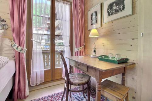 a bedroom with a desk and a bed and a window at Chalet Eden, 4 Story Family Chalet in Champéry