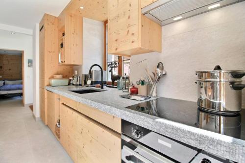 a kitchen with wooden cabinets and a sink at Chalet Eden, 4 Story Family Chalet in Champéry