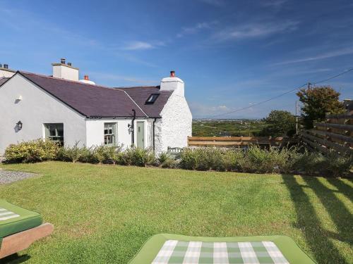 una casa blanca con césped delante en Fferam Gorniog, en Holyhead
