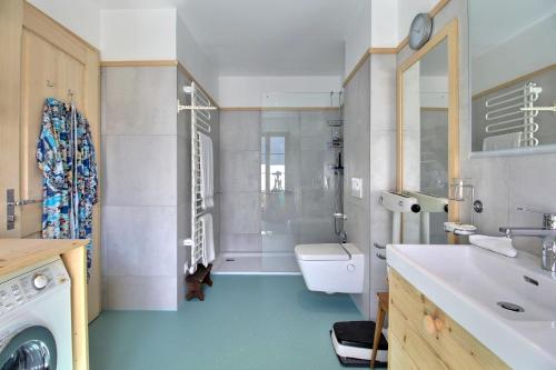 a bathroom with a shower and a sink and a toilet at Chalet Eden, 4 Story Family Chalet in Champéry
