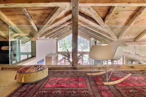 a living room with a chair and a large window at Chalet Eden, 4 Story Family Chalet in Champéry