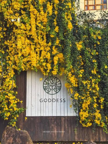 a white door with yellow flowers and the words goodwill at GODDESS Kandy in Kandy
