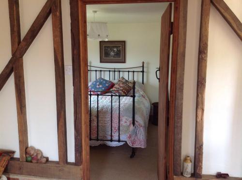 1 dormitorio con 1 cama y puerta de madera en Hops and the Vines, en Shipston on Stour