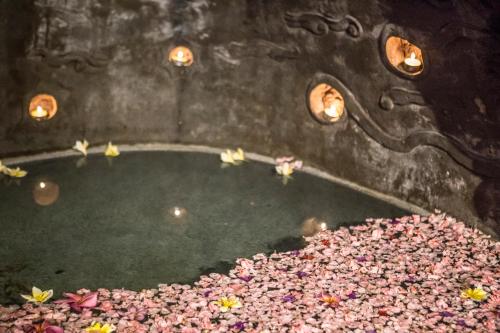 a room with a pond with flowers and lights at Avalon Ubud Castle & SPA in Ubud