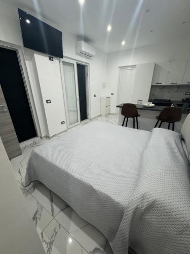 フォリオ・ディスキアにあるP&P Apartmentの大きなベッドと椅子2脚のある白い寝室