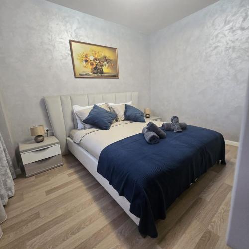 コンスタンツァにあるLuxury 2 Bedroom Apartmentのベッドルーム1室(ブルーシーツと靴が付いたベッド1台付)