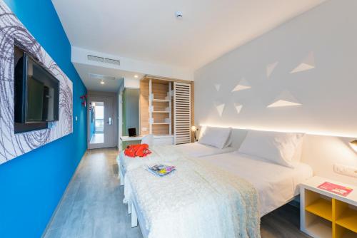 a bedroom with a large bed and a tv at Pharos Hvar Hotel in Hvar