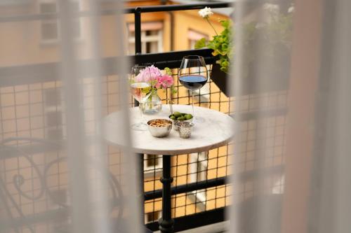 a table with glasses of wine and flowers on a balcony at Villa Dagmar in Stockholm