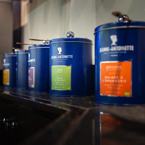 a row of blue canisters sitting on a counter at Logis Hôtel & Restaurant - Les Tuileries in Féy