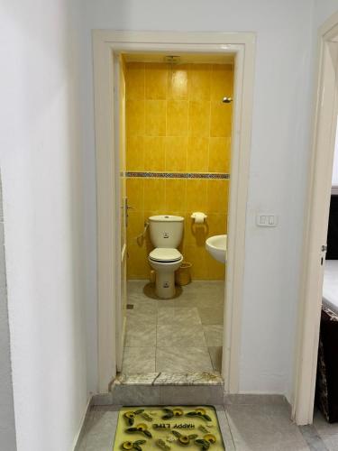 a bathroom with a toilet and a yellow wall at Dar slouma in Kelibia