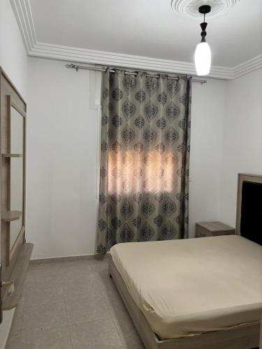 a bedroom with a bed and a curtain at Dar slouma in Kelibia