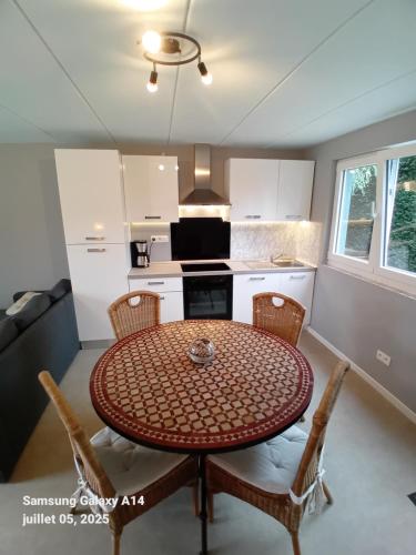 a kitchen with a table and chairs in a room at Gîtes L'Evasion Thudinienne in Thuin