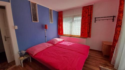 a bedroom with a pink bed in a blue room at Gollrad 1 in Arosa