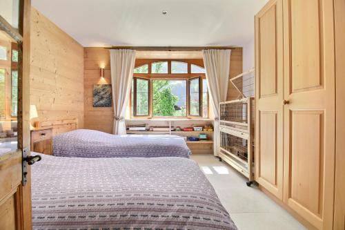 a bedroom with two beds and a window at Chalet Eden, 4 Story Family Chalet in Champéry