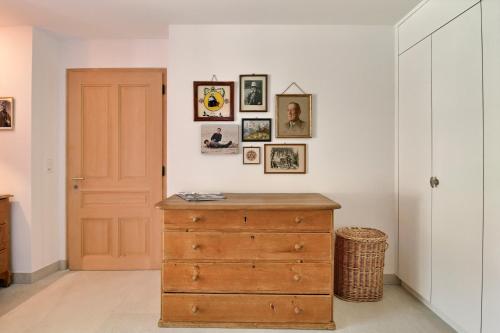 a room with a wooden dresser and pictures on the wall at Chalet Eden, 4 Story Family Chalet in Champéry